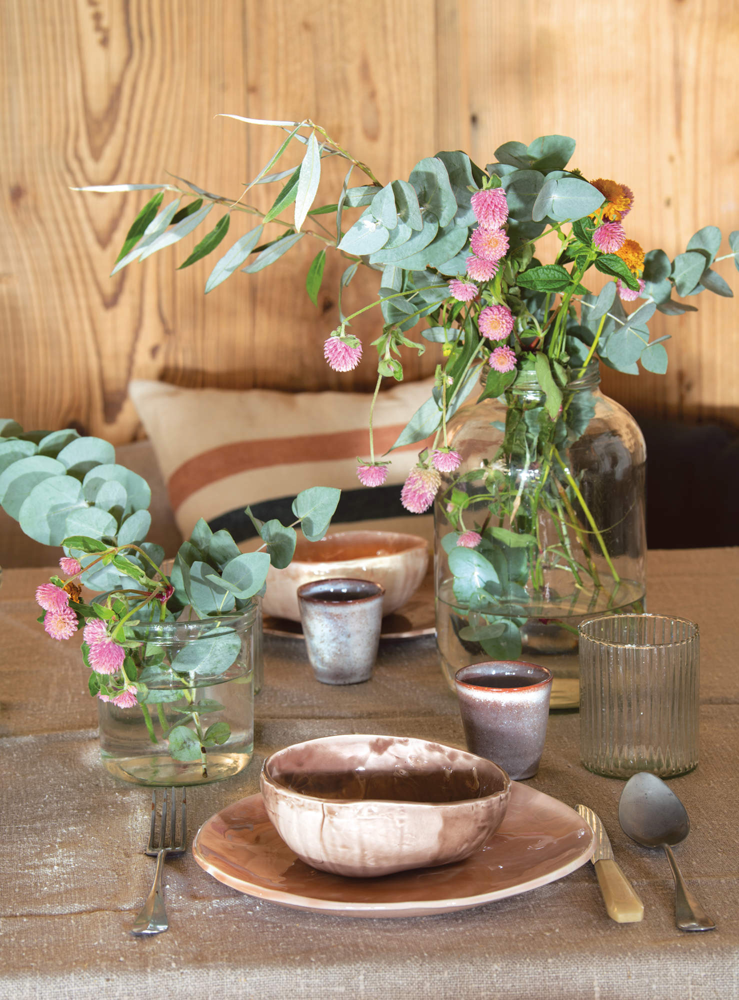 Mesa con vajilla rústica y artesanal con flores
